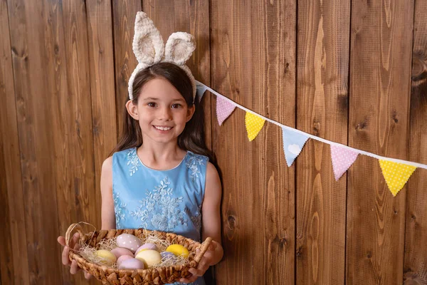 이스터 귀엽게 소녀가 가까이에 색깔있는 달걀이 바구니를 있습니다 아이가 축일을 — 스톡 사진