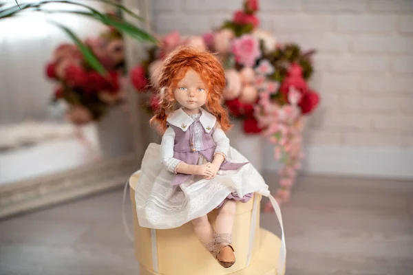 在礼品盒上坐着一个人脸的室内设计娃娃 由纺织品手工制成 风格复古 礼品盒四周环绕着鲜花 为假期创造洋娃娃 洋娃娃的伴侣 — 图库照片