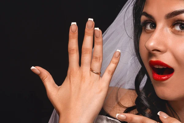 魅力的な花嫁のクローズアップ ベールとウェディングドレスで 婚約指輪で彼女の手を示す 黒の背景に ブルネットは喜びでリングを披露します コンセプトエンゲージメント — ストック写真