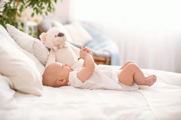 Bonito Bebê Meses Está Deitado Costas Cama Brincando Com Mãos — Fotografia de Stock