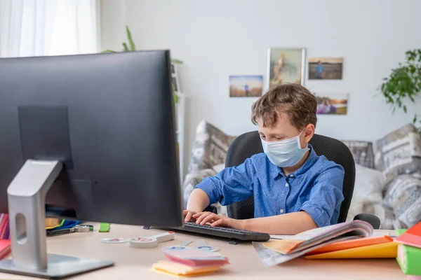 Rapaz Com Uma Máscara Facial Faz Trabalhos Casa Usando Computador — Fotografia de Stock