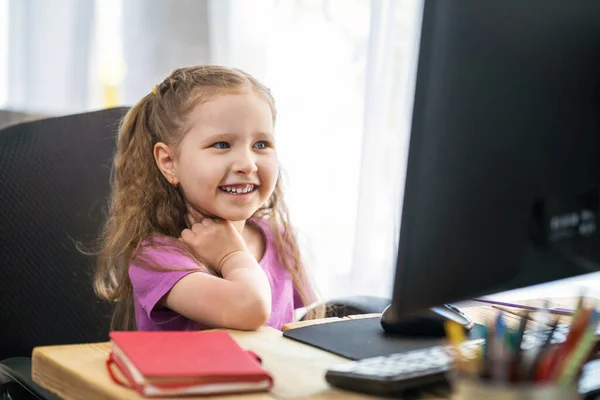 女の子は家で勉強するのにコンピューターを使う 子供は喜んで笑顔で遠隔で知識を得る 電子学習のデジタル概念 流行中 隔離と自己分離 遠隔Eラーニング — ストック写真