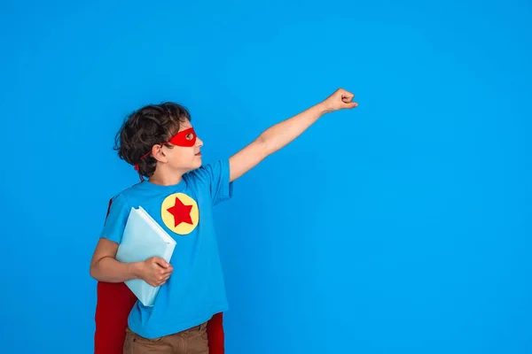 Süper Kahraman Kostümü Giymiş Neşeli Çocuk Kitabı Tutuyor Elini Uzatıyor — Stok fotoğraf