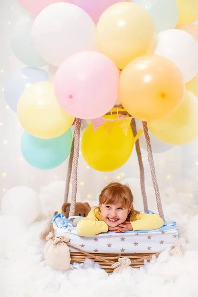 Sorridente Bambina Seduta Palloncino Decorativo Cesto Con Mani Sotto Testa — Foto Stock