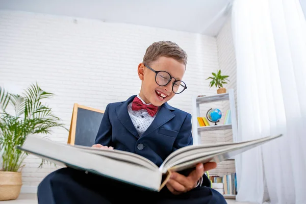 Nerd Schooljongen Met Bril Kijkt Naar Een Boek Glimlacht Grappig — Stockfoto