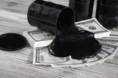 Petrol varil dışında bir yüz dolar faturaları arka plan akar.