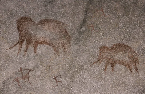 Cave paintings of primitive man. Ocher. Hunters hunt for a mammoth, with weapons in their hands. Caveman.