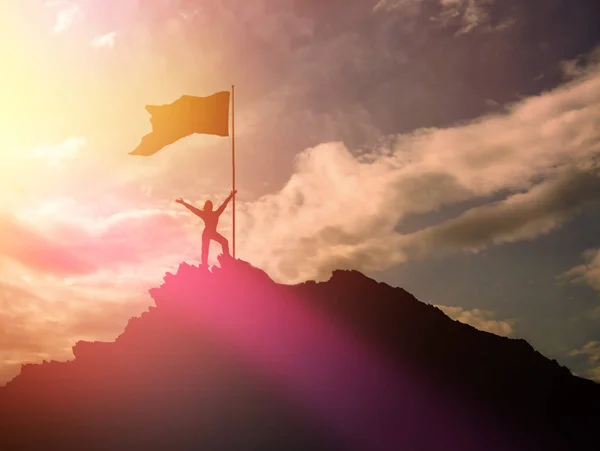 Alta realização, silhuetas da menina, bandeira da vitória no topo da montanha, mãos para cima . — Fotografia de Stock