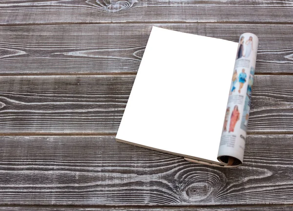 Mock-up female magazine or catalog on a wooden table with flowers.