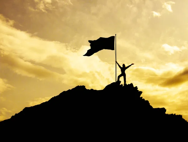 Alta realização, silhuetas da menina, bandeira da vitória no topo da montanha, mãos para cima. Um homem no topo de uma montanha . — Fotografia de Stock