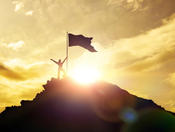 Високі досягнення, силуети дівчини, прапор перемоги на вершині гори, руки вгору . — стокове фото