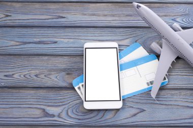 Smartphone, ahşap bir masa arka plan üzerinde uçak biletleri