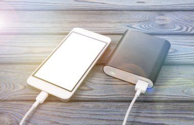 Smartphone, ahşap bir masa arka plan üzerinde şarj cihazı