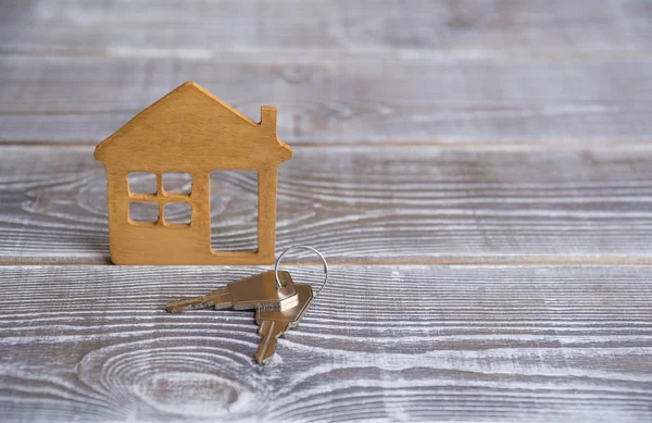 Schlüssel Mit Einem Haus Aus Natürlichem Holz Auf Einem Holz Stockbild