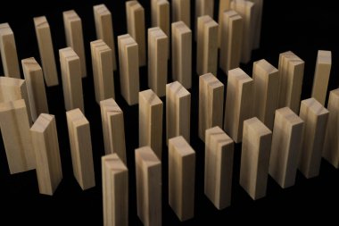 Yılan domino doğal ahşap, domino etkisi, eliyle çökmekte itibaren ahşap Domino tuğla önünde. Siyah bir arka plan üzerinde