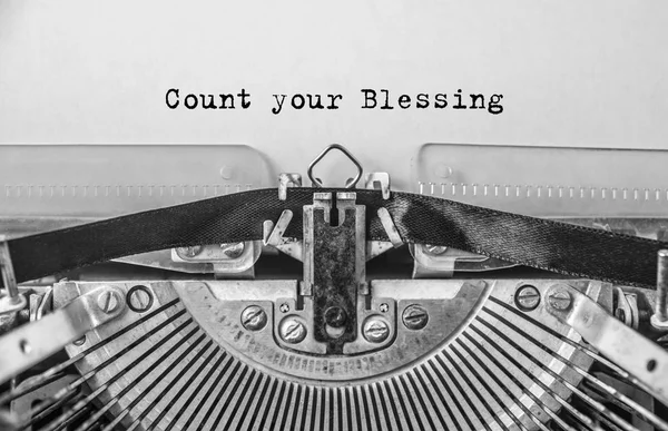 Vintage old typewriter on white background with text Count your Blessing. Close up.