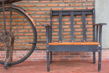 Turuncu tuğla duvarlar ve eski bisiklet üzerinde ahşap sandalye.