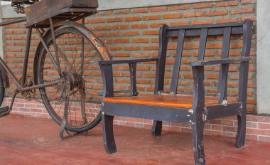 Turuncu tuğla duvarlar ve eski bisiklet üzerinde ahşap sandalye.