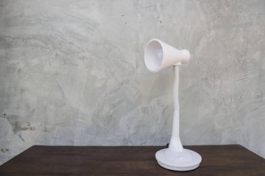 Ahşap masa duvar gri arka plan üzerinde izole beyaz masa lambası .