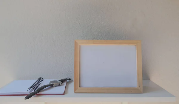 Foto Cornice su un legno e libro su sfondo bianco — Foto Stock