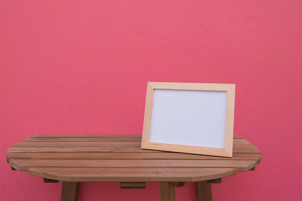 Фото Рамка на деревянном фоне на розовом фоне  . — стоковое фото