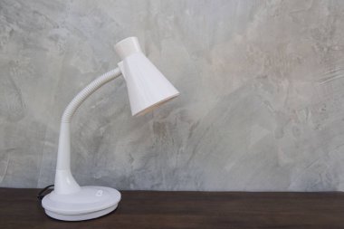 Ahşap masa duvar gri arka plan üzerinde izole beyaz masa lambası .