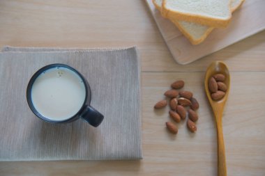 Ahşap masa günü kahvaltıda ekmek ve badem süt fincan Üstten Görünüm