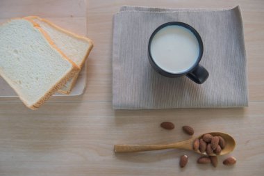 Ahşap masa günü kahvaltıda ekmek ve badem süt fincan Üstten Görünüm
