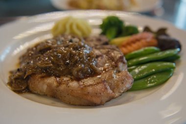 Domuz eti biftek ve beyaz tabakta sebze . 