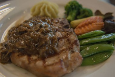 Domuz eti biftek ve beyaz tabakta sebze . 