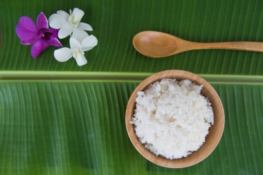 Üstten Görünüm pişmiş pirinç kase yeşil muz yaprak kaşık ve orkide .