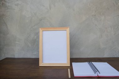 bir ahşap masa ve gri duvar arka plan üzerinde kitap fotoğraf çerçevesi .