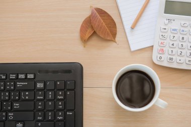 Ofiste iş nesneleri. fincan kahve ve ahşap masa üstünde klavye .