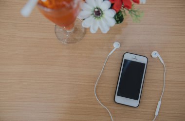 Üstten Görünüm telefon ve kulaklık üzerinde arka plan için ahşap masa.