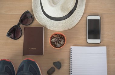 Üstten görünüm kavramı seyahat aksesuarları. Şapka, kitap, telefon, Ayakkabı, pasaport, güneş gözlüğü