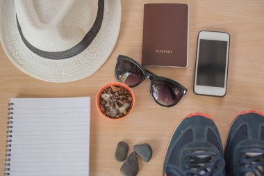 Üstten görünüm kavramı seyahat aksesuarları. Şapka, kitap, telefon, Ayakkabı, pasaport, güneş gözlüğü