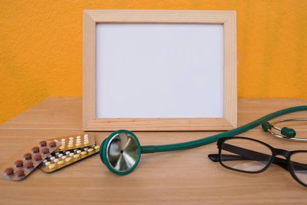 photo Frame and stethoscope on a wooden on Yellow background .