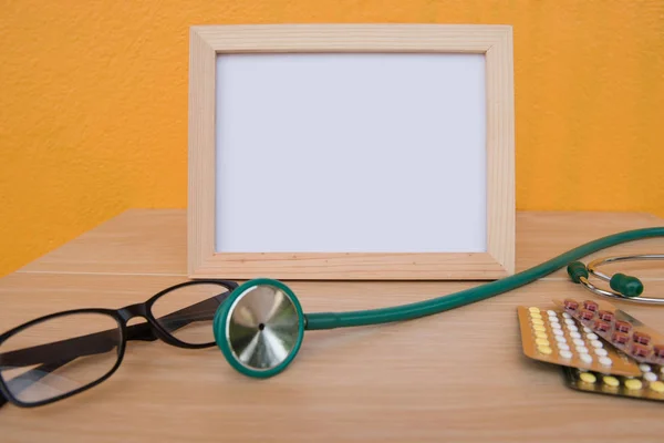 photo Frame and stethoscope on a wooden on Yellow background .