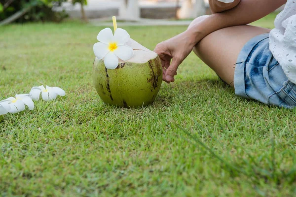 Kokosnuss und Frauen entspannen sich auf dem grünen Gras — Stockfoto