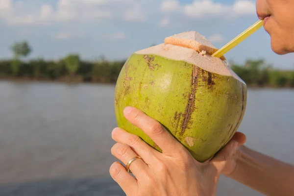 Nahaufnahme Kokosnuss, Frauen genießen das Trinken von Saft blauen Himmel Hintergrund — Stockfoto