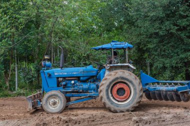 Grupta tarım işçileri ile çalışan bir traktör 