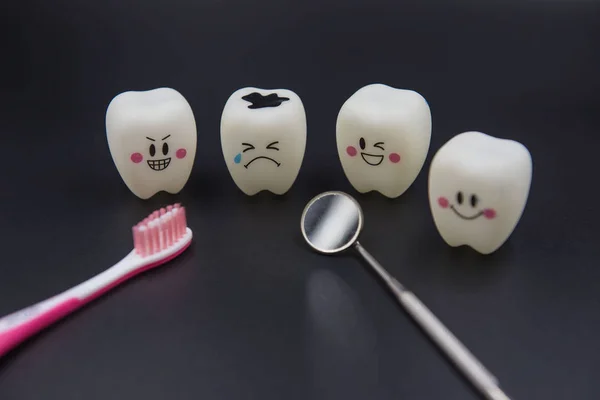 Modelo Bonito brinquedos dentes na odontologia em um fundo preto — Fotografia de Stock