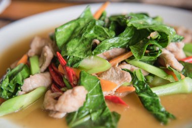 closeup kale ile beyaz bir plaka üzerinde domuz kızarmış. Tayland gıda