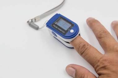 Pulse oximeter in a male patient's fingertip  on white background clipart