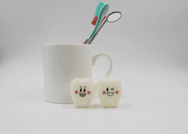 Model beyaz bir arka plan üzerinde sevimli oyuncaklar diş ve cam