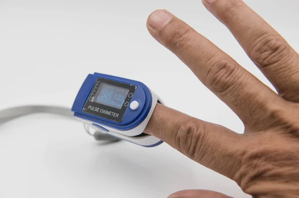 Nabız oksimetre beyaz arka plan üzerinde bir erkek hastanın parmak ucu