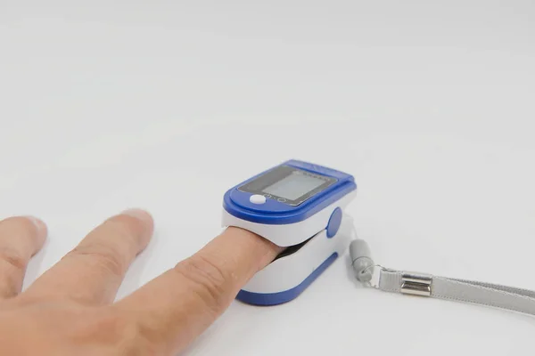 Pulse oximeter i en manlig patients fingertoppen på vit bakgrund — Stockfoto