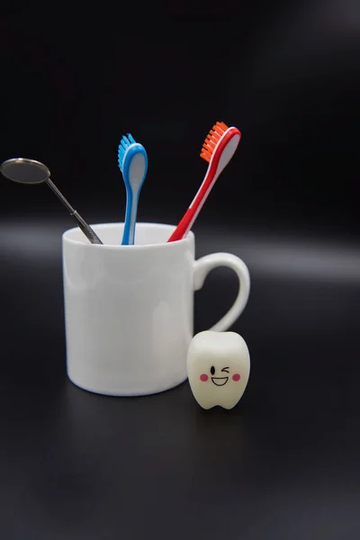 Modelo Bonito brinquedos dentes e vidro em um fundo preto — Fotografia de Stock