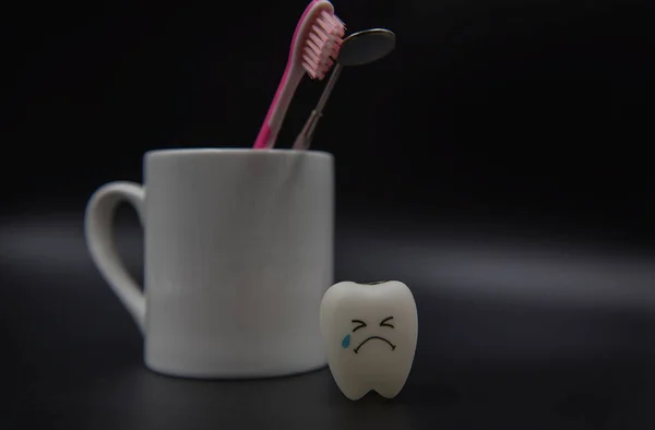 Modelo Bonito brinquedos dentes e vidro em um fundo preto — Fotografia de Stock