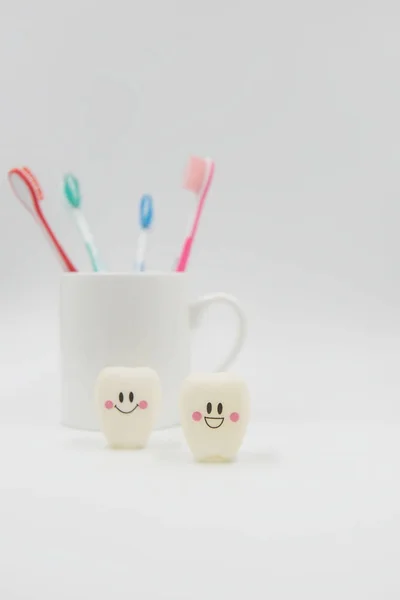 Modelo Bonito brinquedos dentes e vidro em um fundo branco — Fotografia de Stock